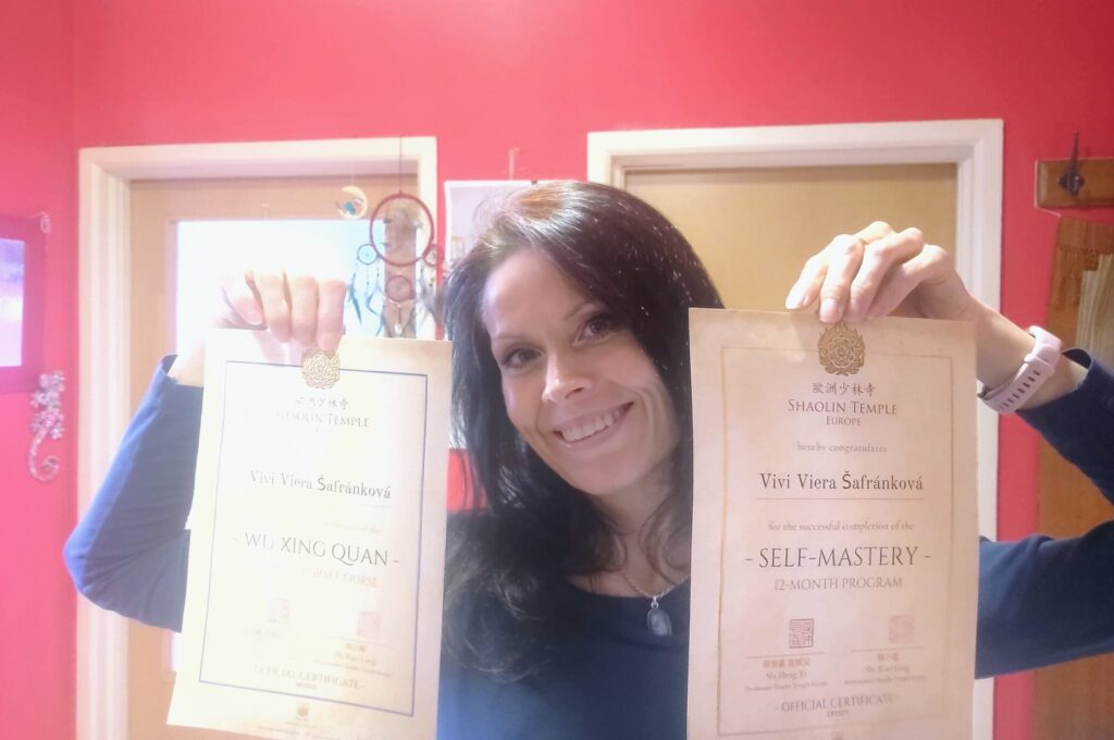 Vivi holding two certificates and smiling